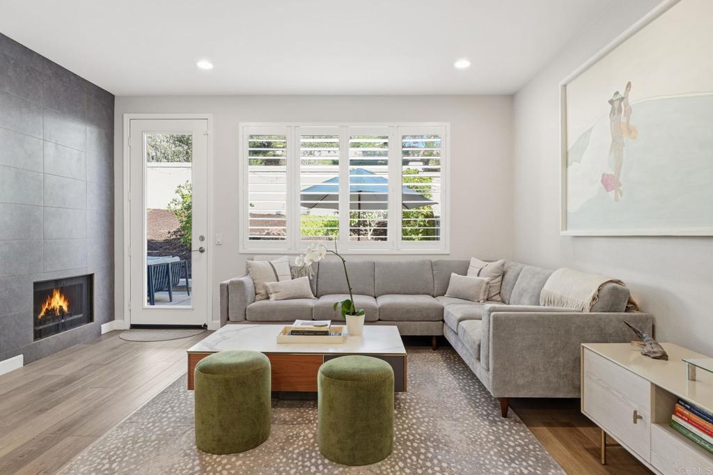 6485 Alexandri Circle Carlsbad, CA 92011 - Photo 8 of 40 a living room with furniture a fireplace and a floor to ceiling window