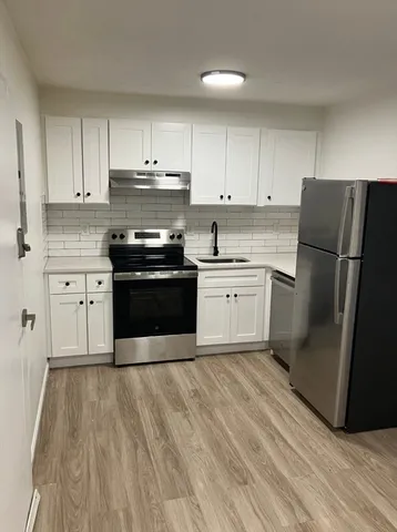 a kitchen with wooden cabinets and stainless steel appliances