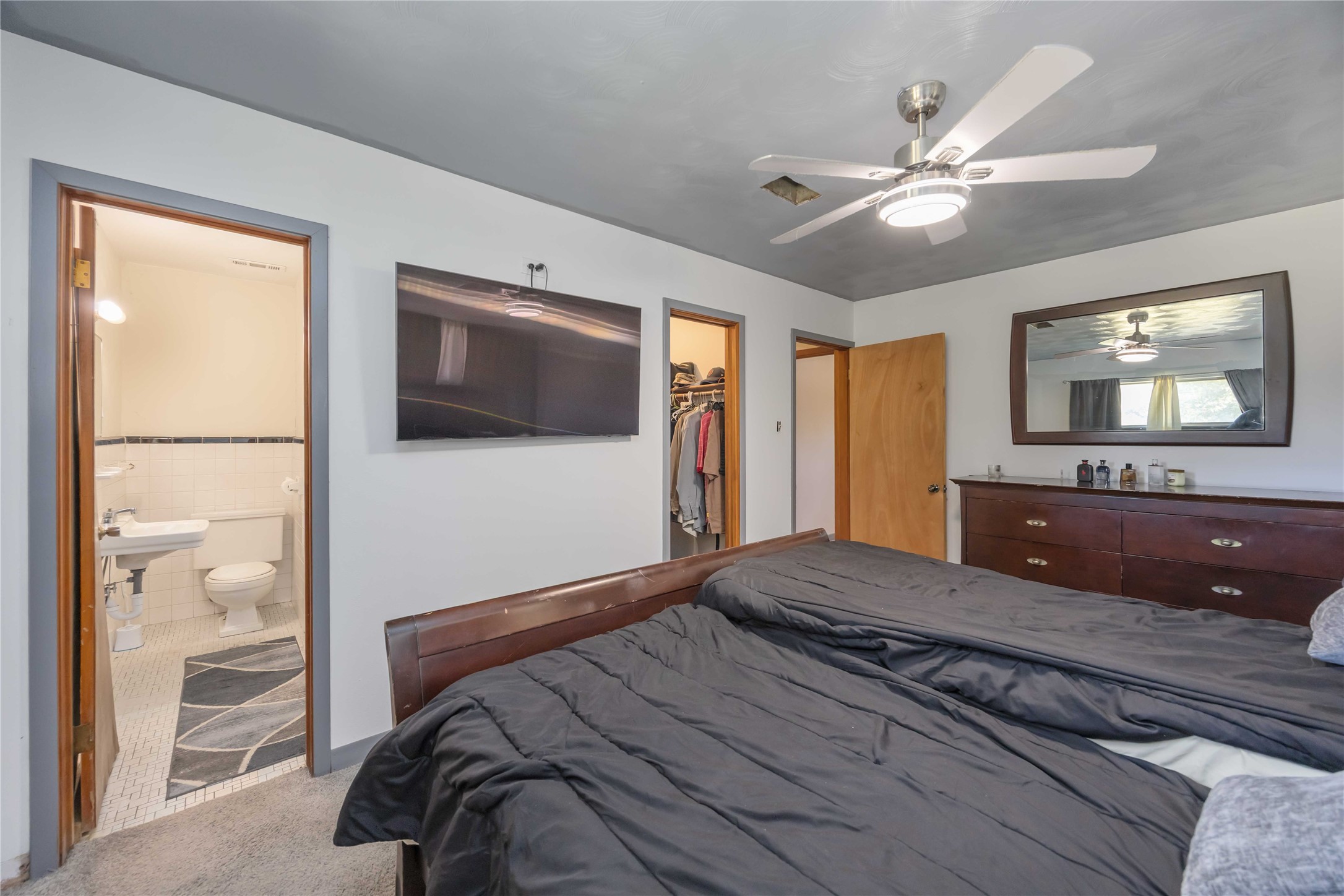 615 Massey Tompkins Road Baytown, TX 77521 - Photo 11 of 25 a bedroom with a large bed and a flat screen tv