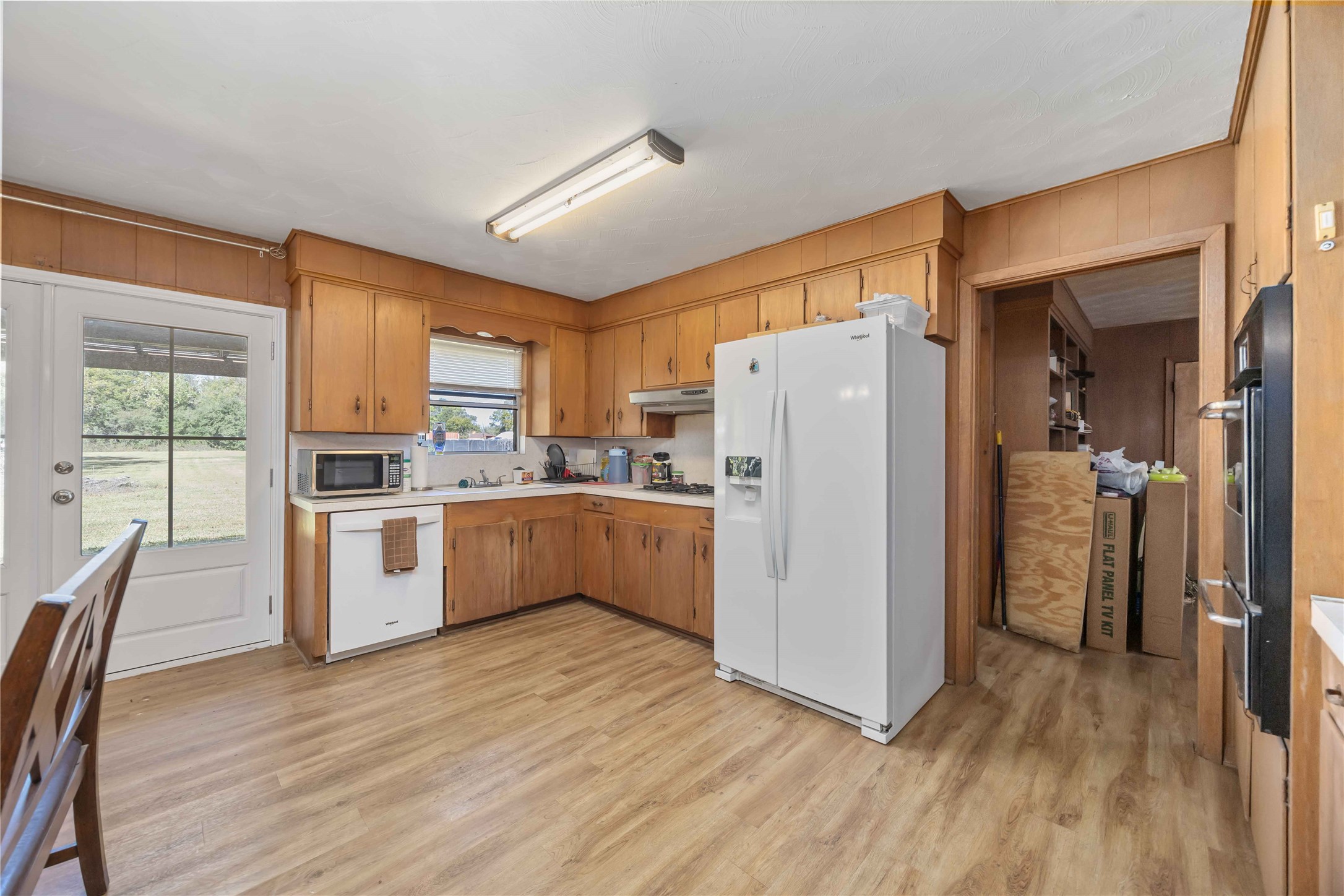 615 Massey Tompkins Road Baytown, TX 77521 - Photo 7 of 25 a kitchen with a refrigerator a microwave oven cabinets and wooden floor
