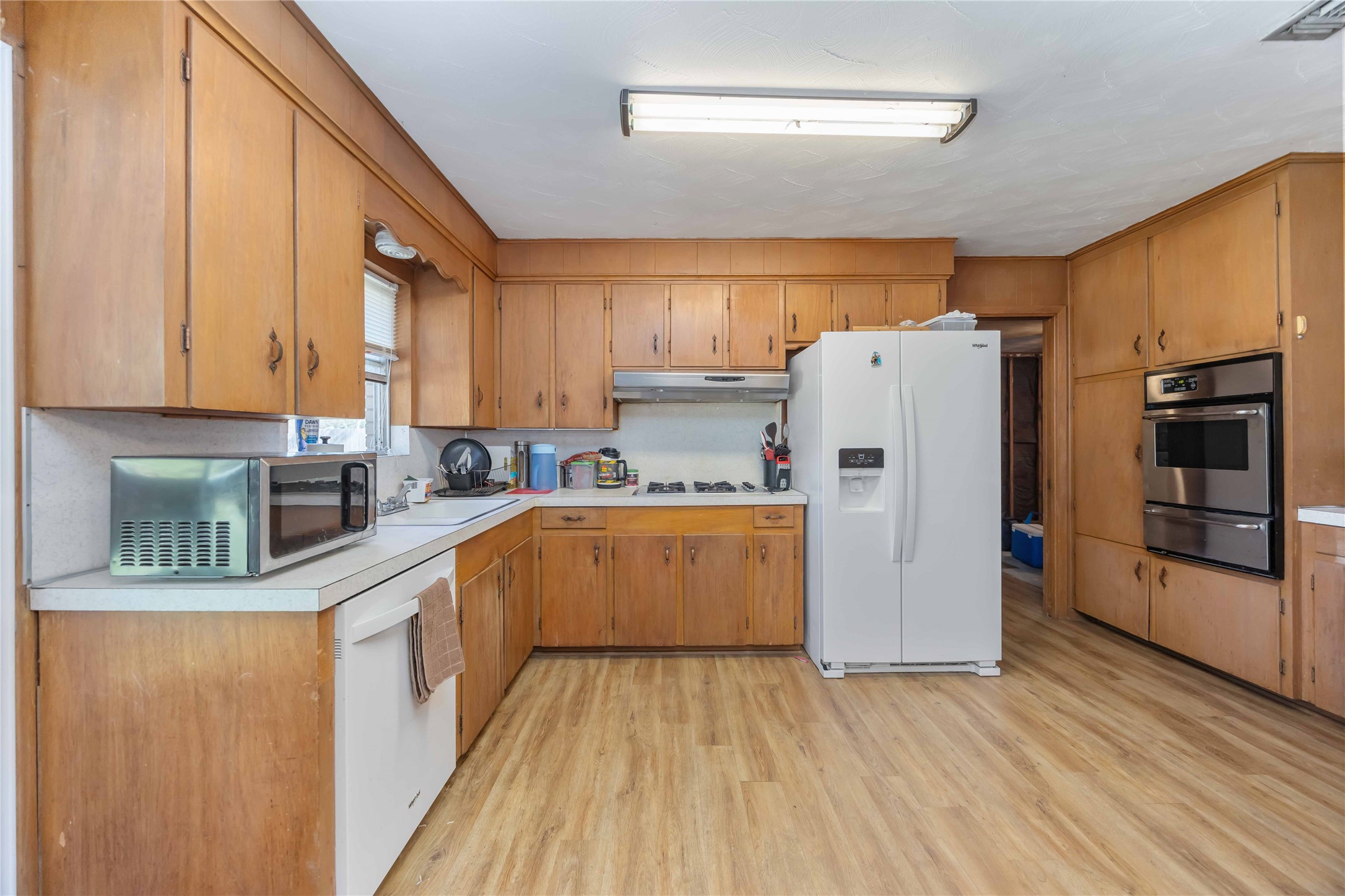 615 Massey Tompkins Road Baytown, TX 77521 - Photo 8 of 25 a kitchen with a refrigerator a stove top oven a sink and dishwasher with wooden floor
