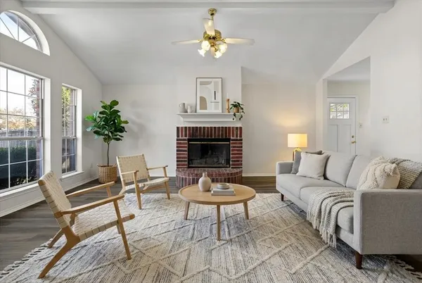 a living room with furniture a fireplace and a window