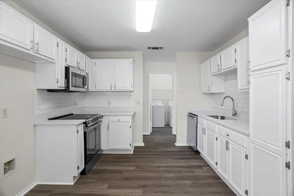 a kitchen with white cabinets stainless steel appliances and sink