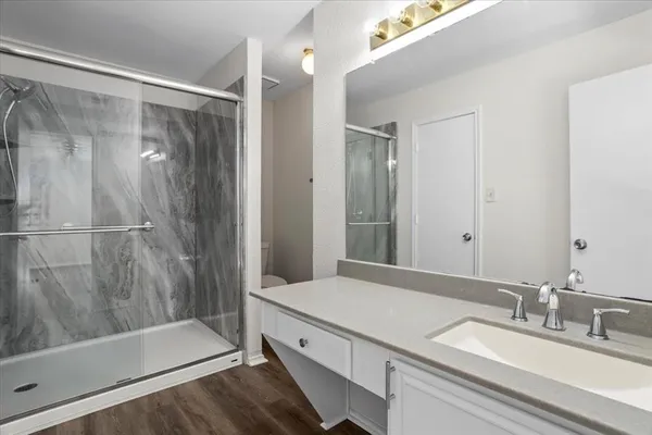 a bathroom with a granite countertop sink mirror and shower