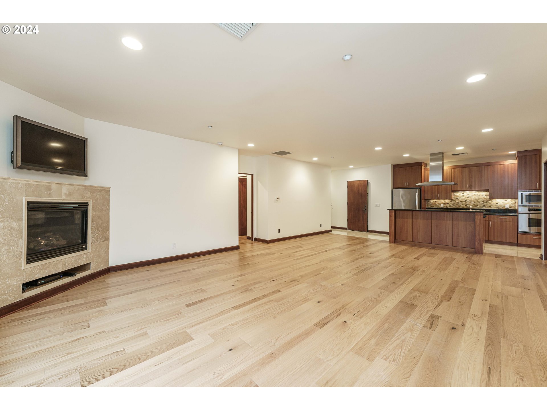 3030 Northwest Montara Loop Portland, OR 97229 - Photo 16 of 37 a view of kitchen and empty room with wooden floor