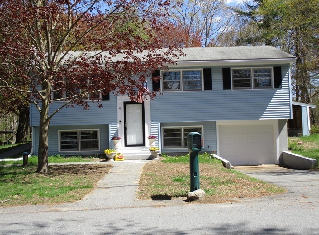 a front view of a house with garage and yard