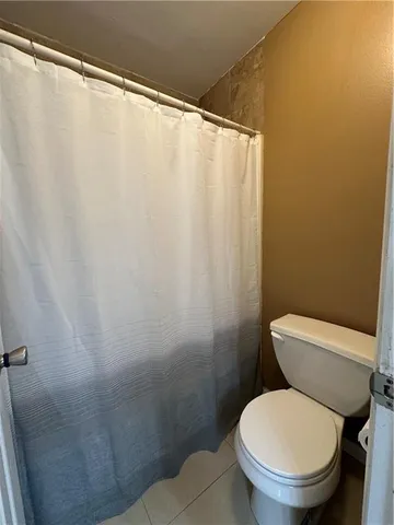 a white toilet sitting next to a shower curtain