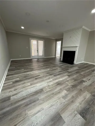 a view of empty room with wooden floor and fireplace
