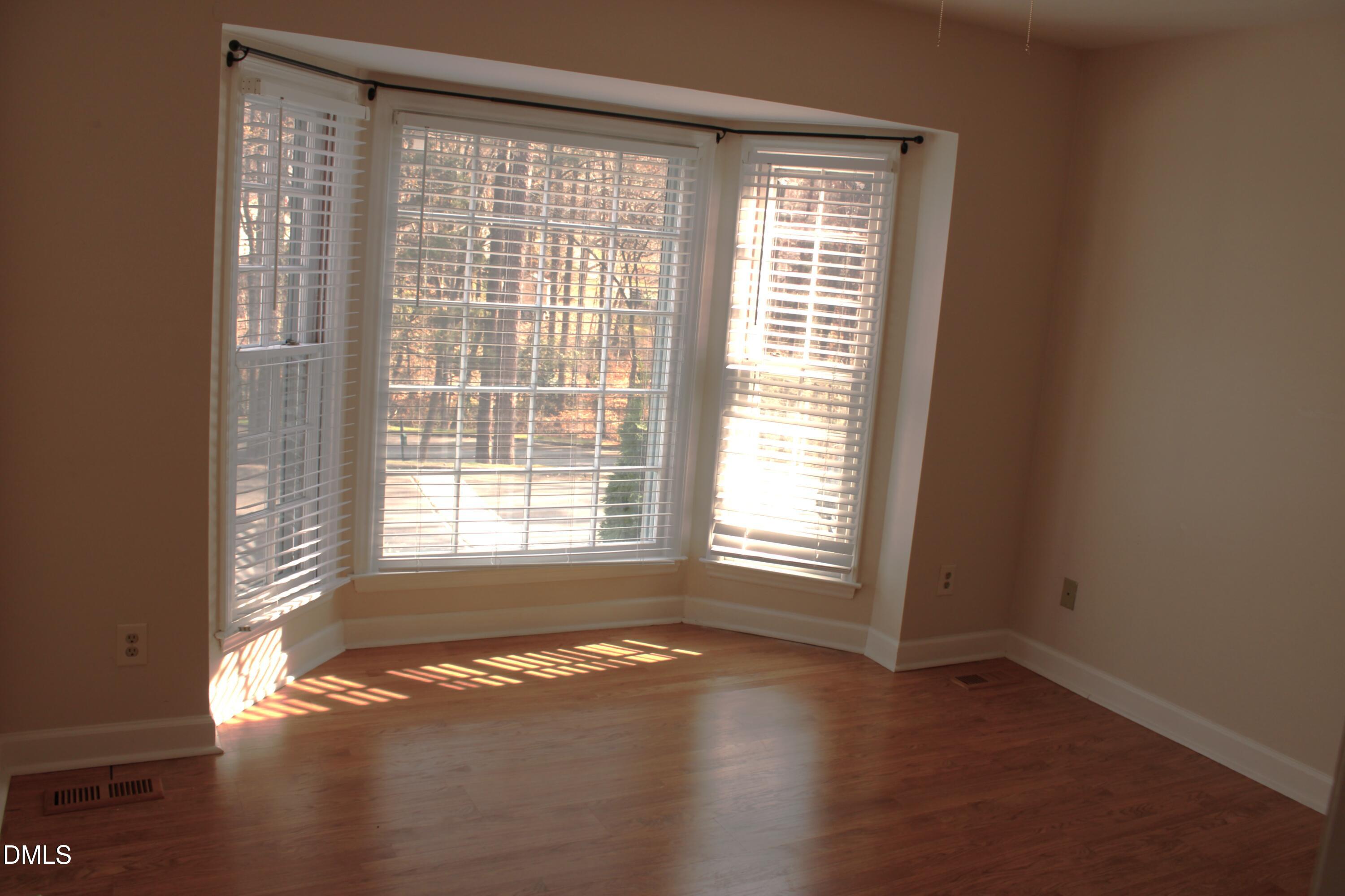 6701 Queen Annes Drive Raleigh, NC 27613 - Photo 12 of 23 a view of empty room with wooden floor and a window