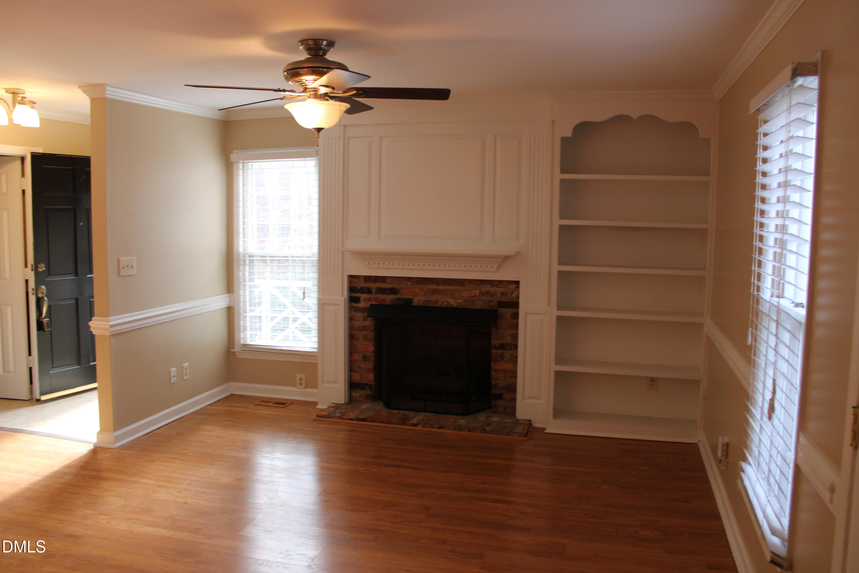 6701 Queen Annes Drive Raleigh, NC 27613 - Photo 4 of 23 a view of a livingroom with a fireplace a ceiling fan and windows