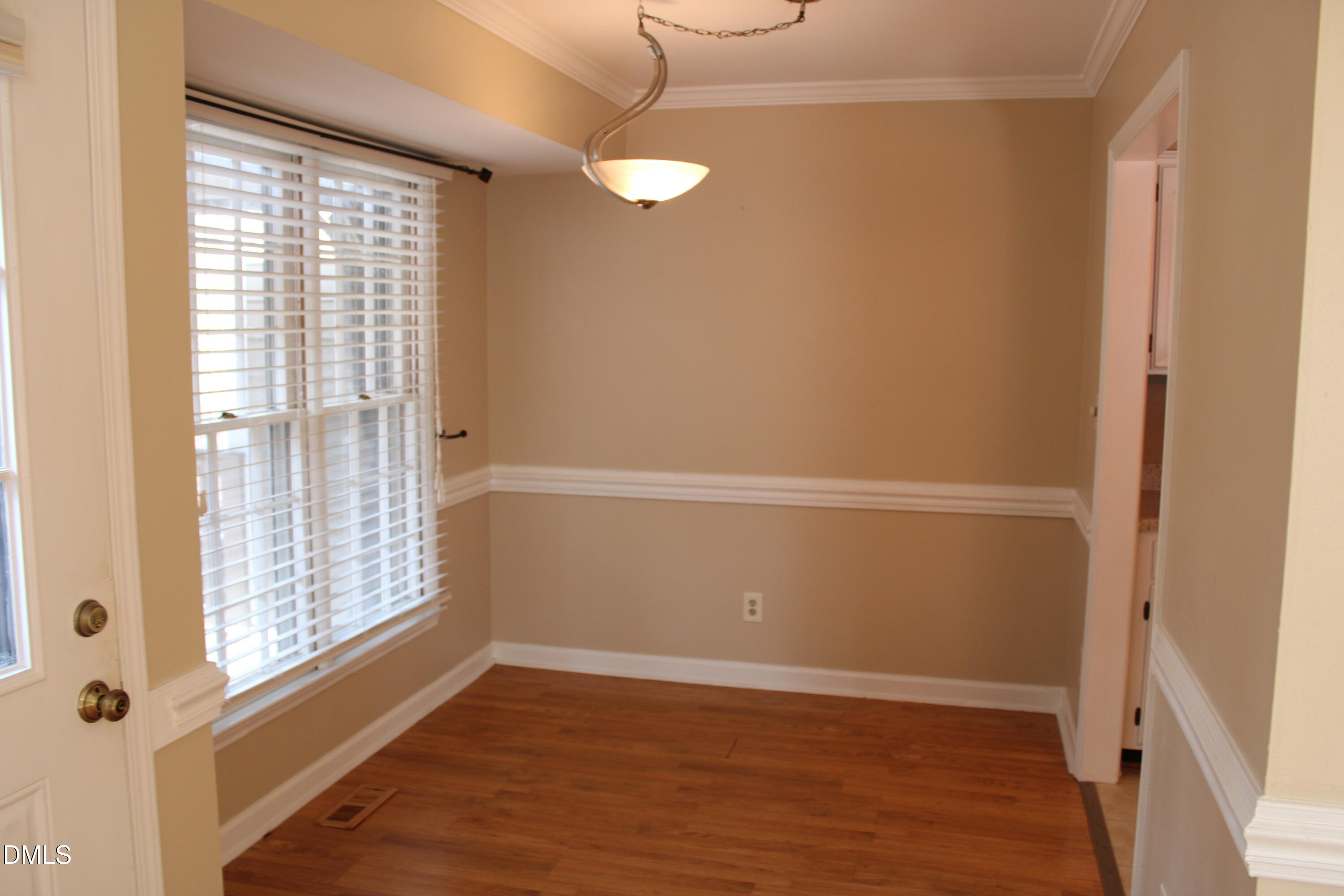 6701 Queen Annes Drive Raleigh, NC 27613 - Photo 5 of 23 a view of an empty room with wooden floor and a window