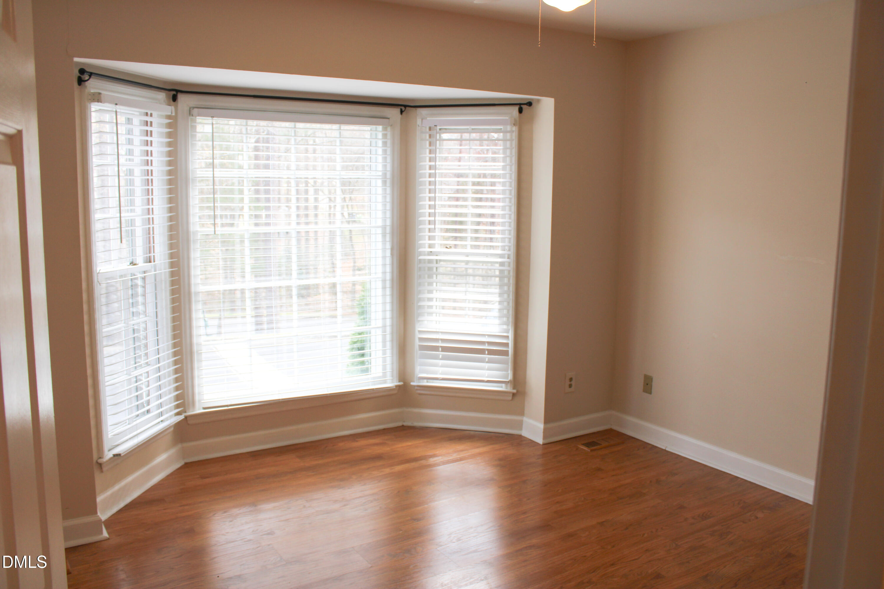 6701 Queen Annes Drive Raleigh, NC 27613 - Photo 10 of 23 a view of an empty room with wooden floor and a window