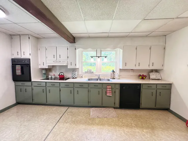 a kitchen with sink a microwave and cabinets