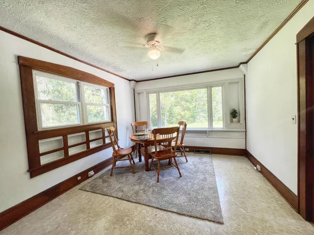 a dining room with furniture and a large window