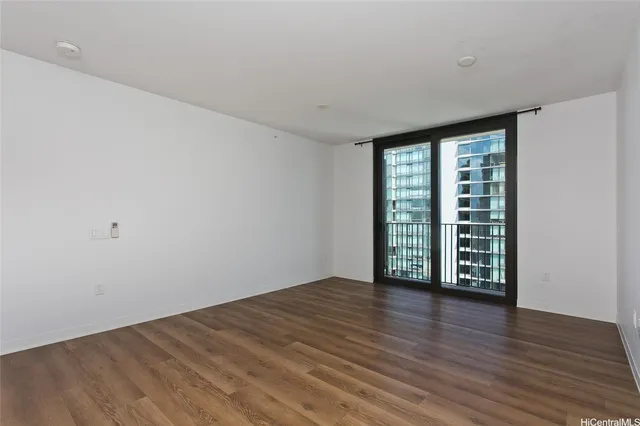 a view of a kitchen with a refrigerator and wooden floor