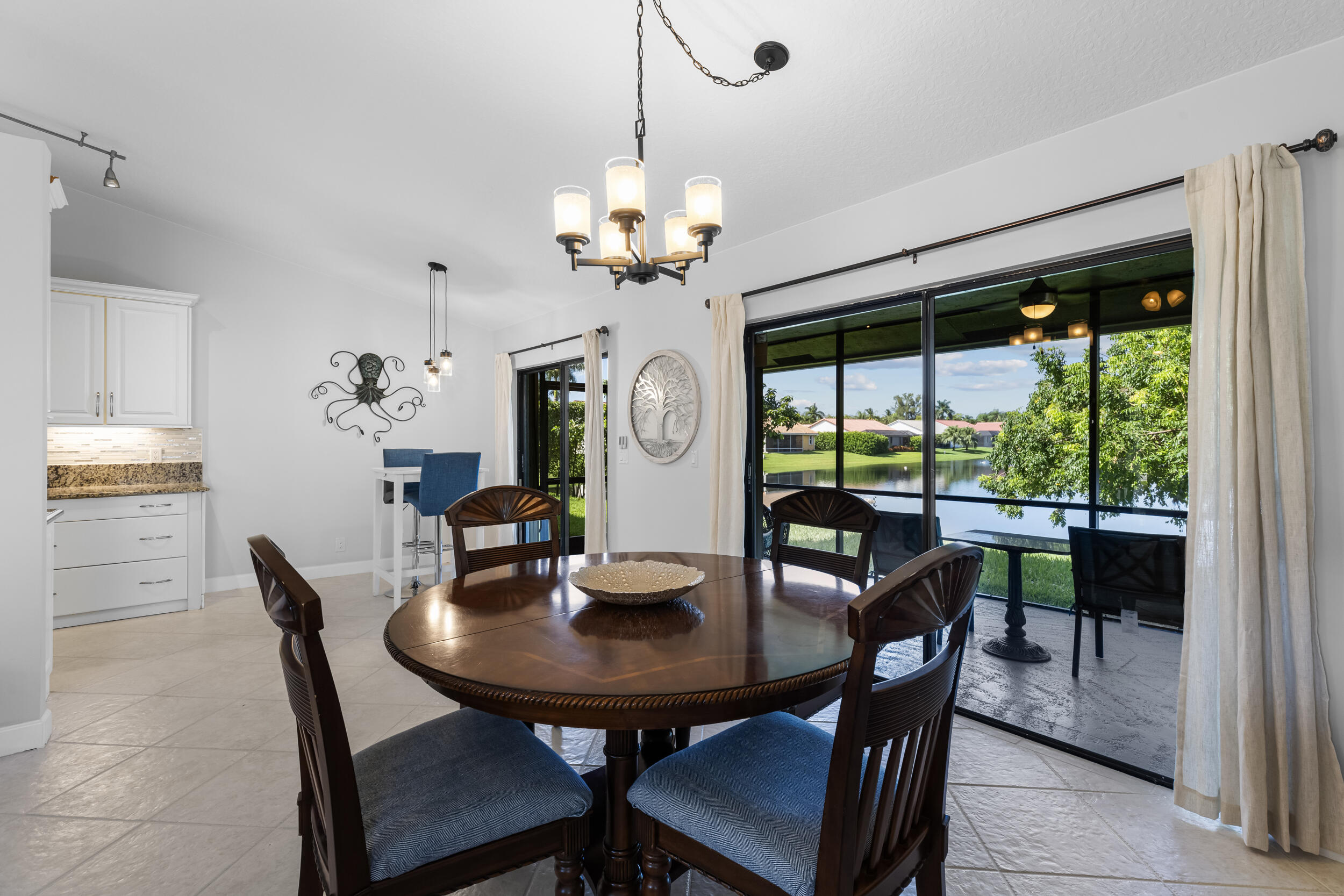 14451 Parker Ridge Court Delray Beach, FL 33484 - Photo 12 of 48 a view of a dining room with furniture a chandelier and large windows