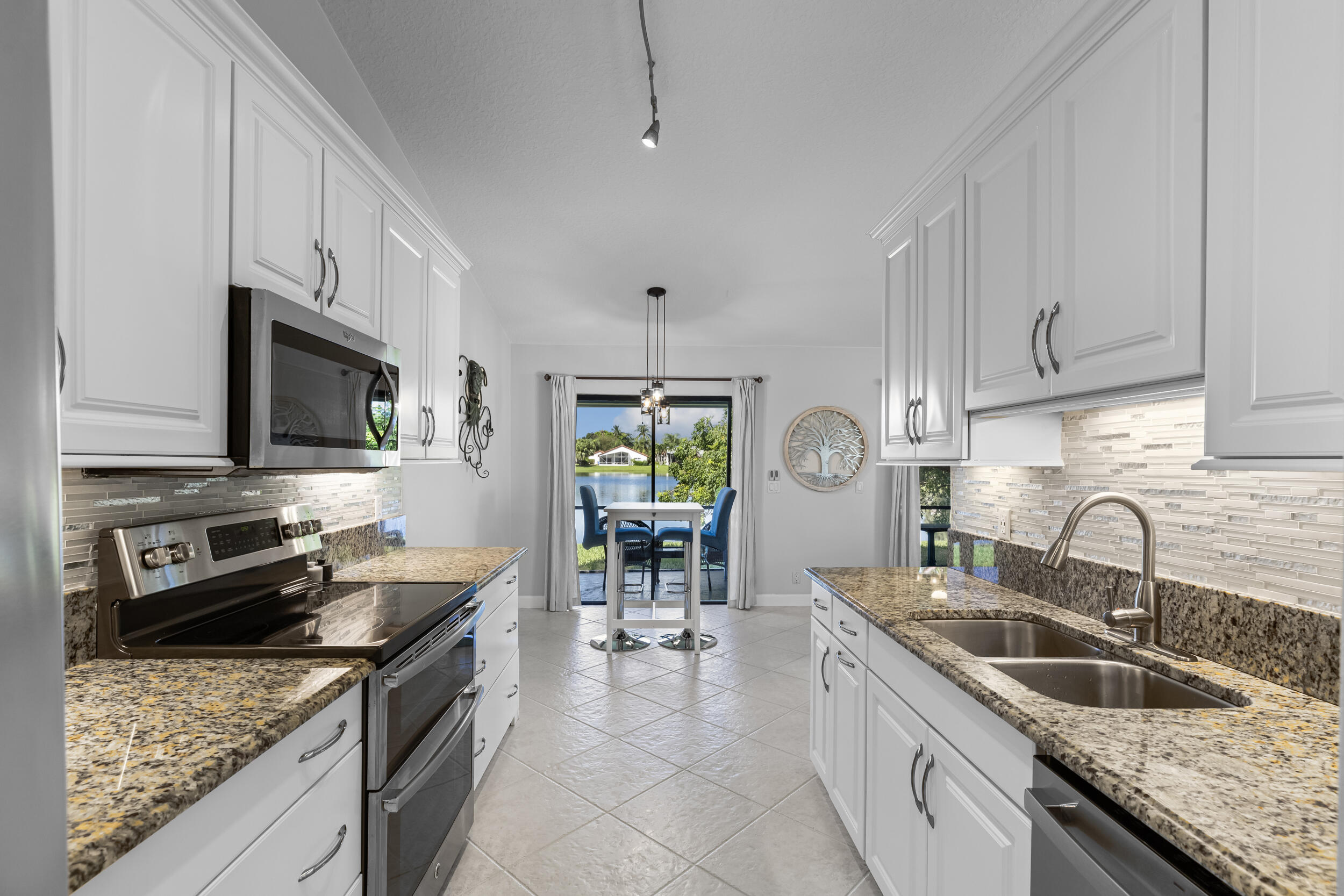14451 Parker Ridge Court Delray Beach, FL 33484 - Photo 18 of 48 a kitchen with stainless steel appliances granite countertop a sink stove and refrigerator