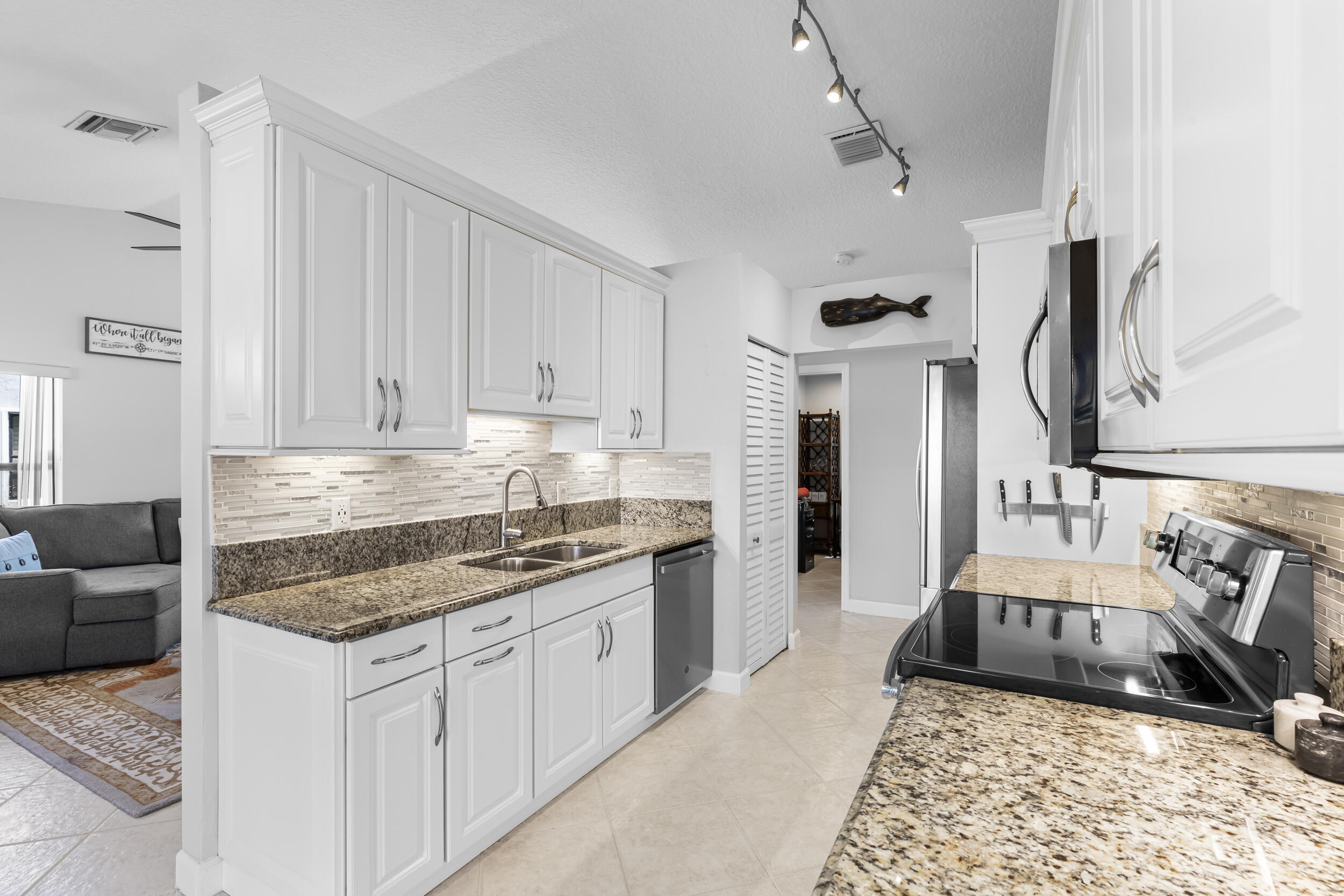 14451 Parker Ridge Court Delray Beach, FL 33484 - Photo 19 of 48 a kitchen with stainless steel appliances granite countertop a stove a sink and a refrigerator