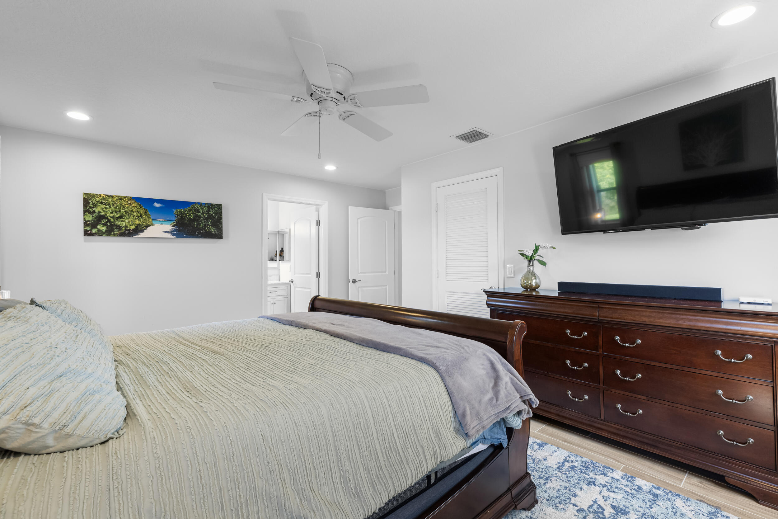 14451 Parker Ridge Court Delray Beach, FL 33484 - Photo 26 of 48 a bedroom with a bed a flat screen tv and a dresser