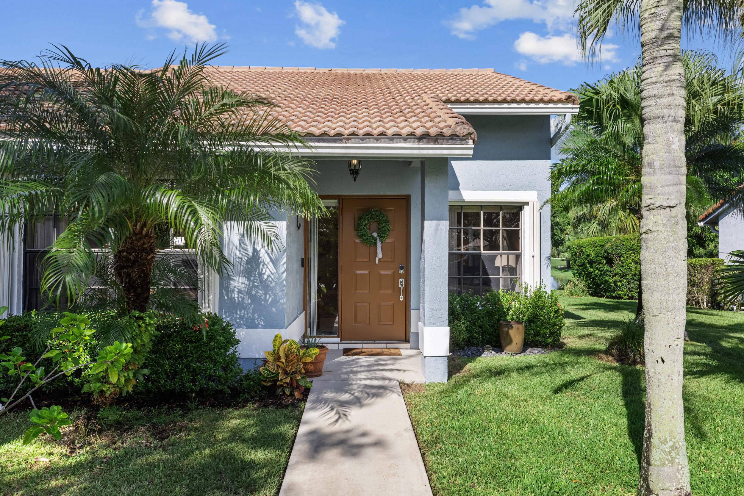 14451 Parker Ridge Court Delray Beach, FL 33484 - Photo 3 of 48 a front view of a house with garden