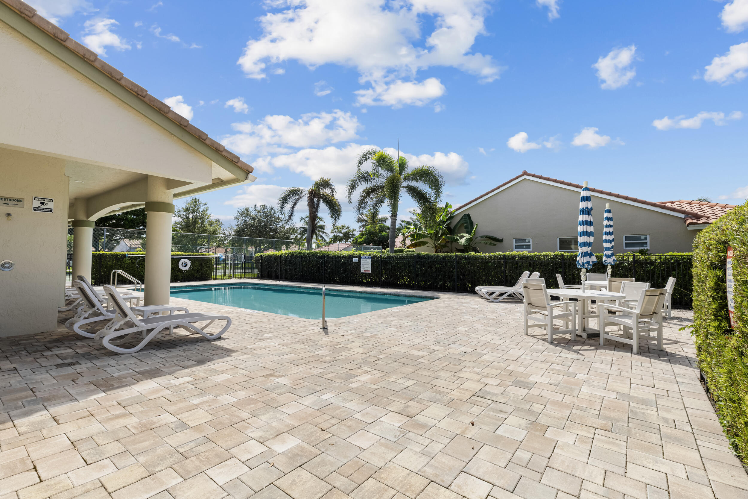 14451 Parker Ridge Court Delray Beach, FL 33484 - Photo 45 of 48 a view of a patio with a dining table and chairs with wooden floor