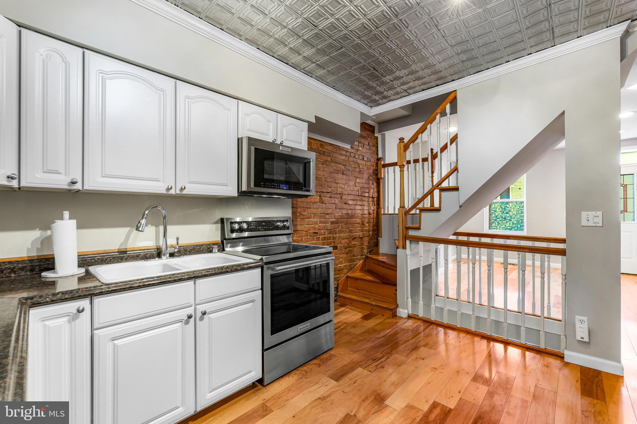 1432 Haubert Street Baltimore, MD 21230 - Photo 8 of 28 a kitchen with stainless steel appliances granite countertop a stove a sink and a microwave