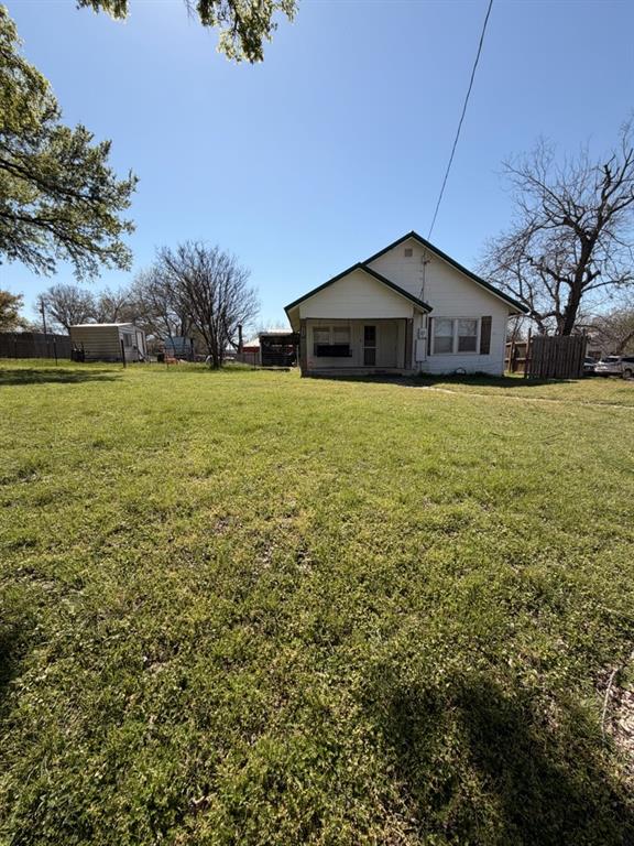 200 South Cleveland Street Meridian, TX 76665 - Photo 1 of 1 a house with green field in front of it