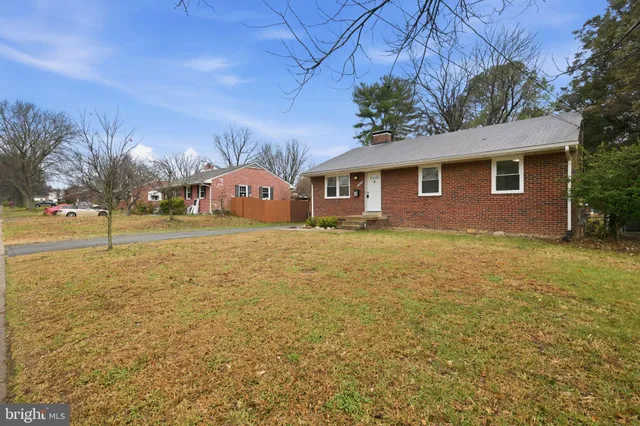 a front view of house with yard and trees around