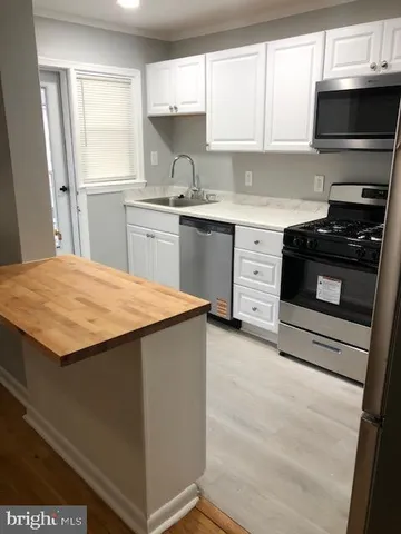 a kitchen with a stove a sink and a microwave