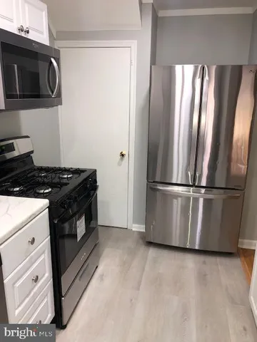 a kitchen with granite countertop a refrigerator and a stove top oven
