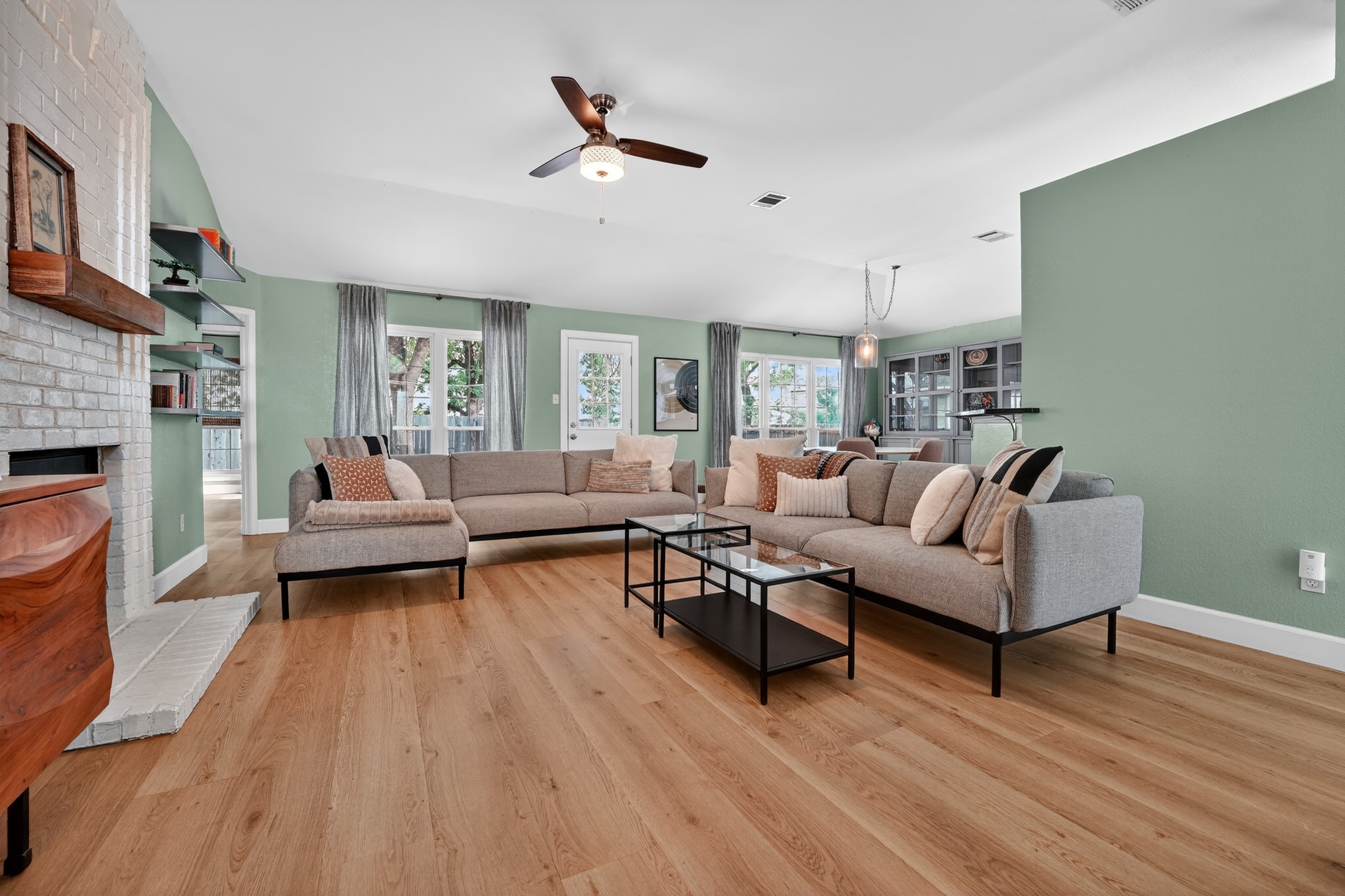 1811 Old Mill Road Cedar Park, TX 78613 - Photo 6 of 39 An inviting open-concept living space features light wood flooring and a classic brick fireplace.