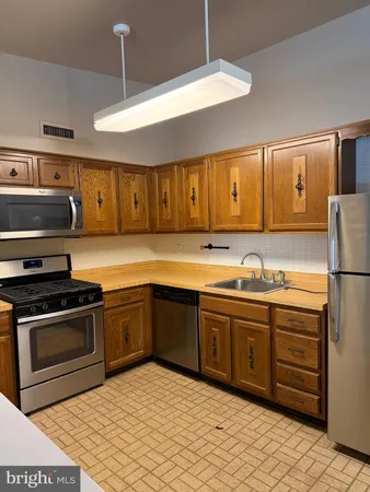 a kitchen with stainless steel appliances granite countertop a sink and cabinets
