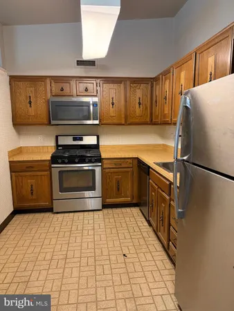 a kitchen with stainless steel appliances granite countertop a stove a sink dishwasher and a refrigerator