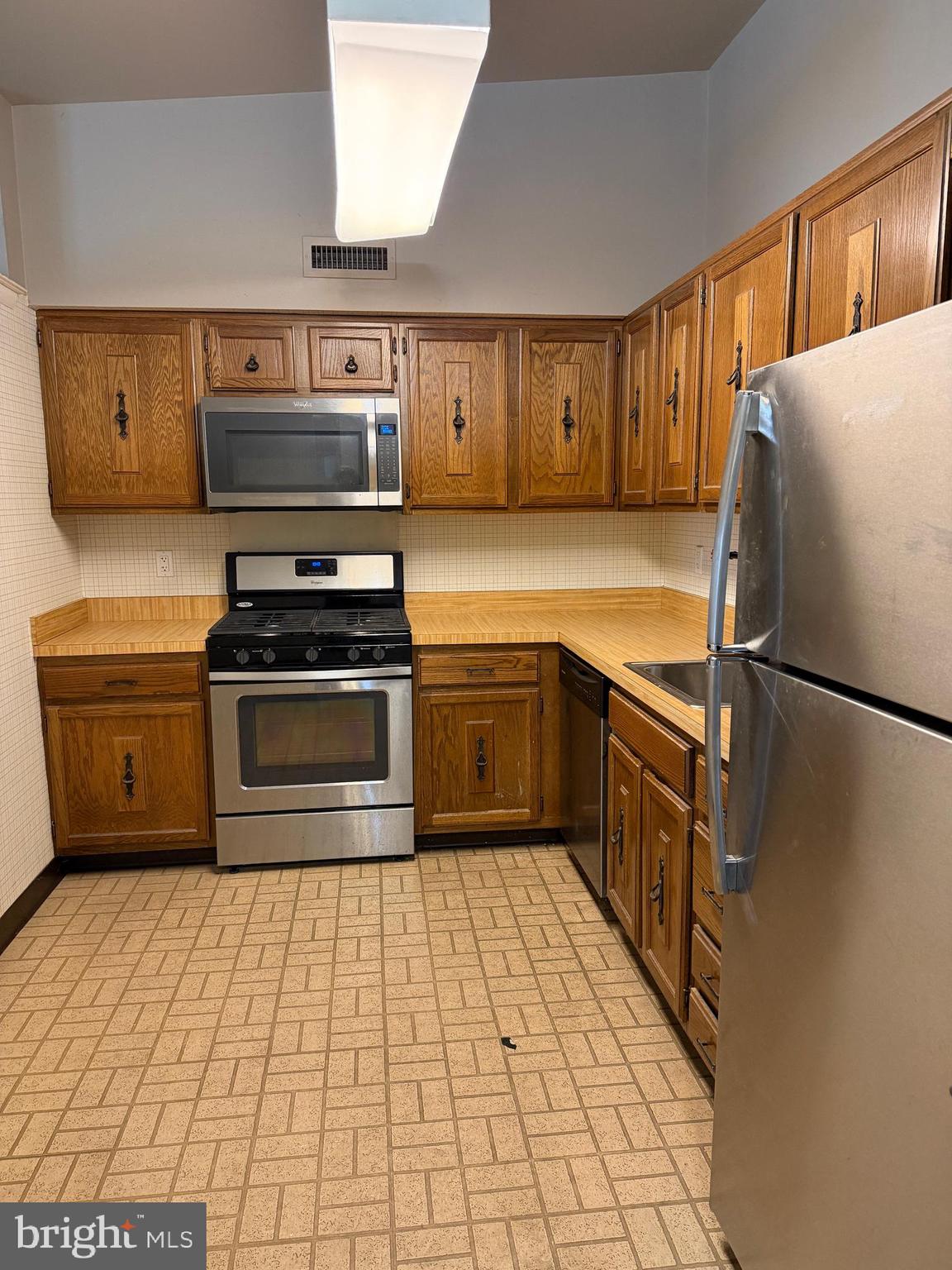 67203 Delaire Landing Road, Unit 203 Philadelphia, PA 19114 - Photo 3 of 29 a kitchen with stainless steel appliances granite countertop a stove a sink dishwasher and a refrigerator