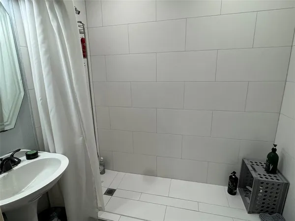 a bathroom with a sink a toilet and shower curtain