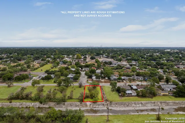 an aerial view of residential houses with outdoor space and parking