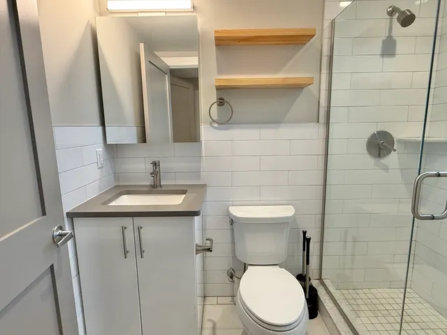 a bathroom with a sink a toilet and shower