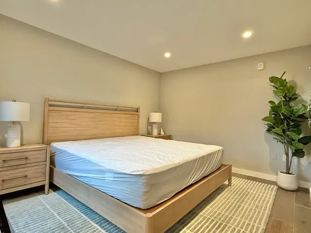 a bedroom with a bed and a potted plant