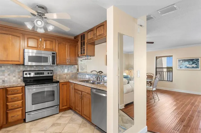 a kitchen with stainless steel appliances granite countertop a stove sink and cabinets