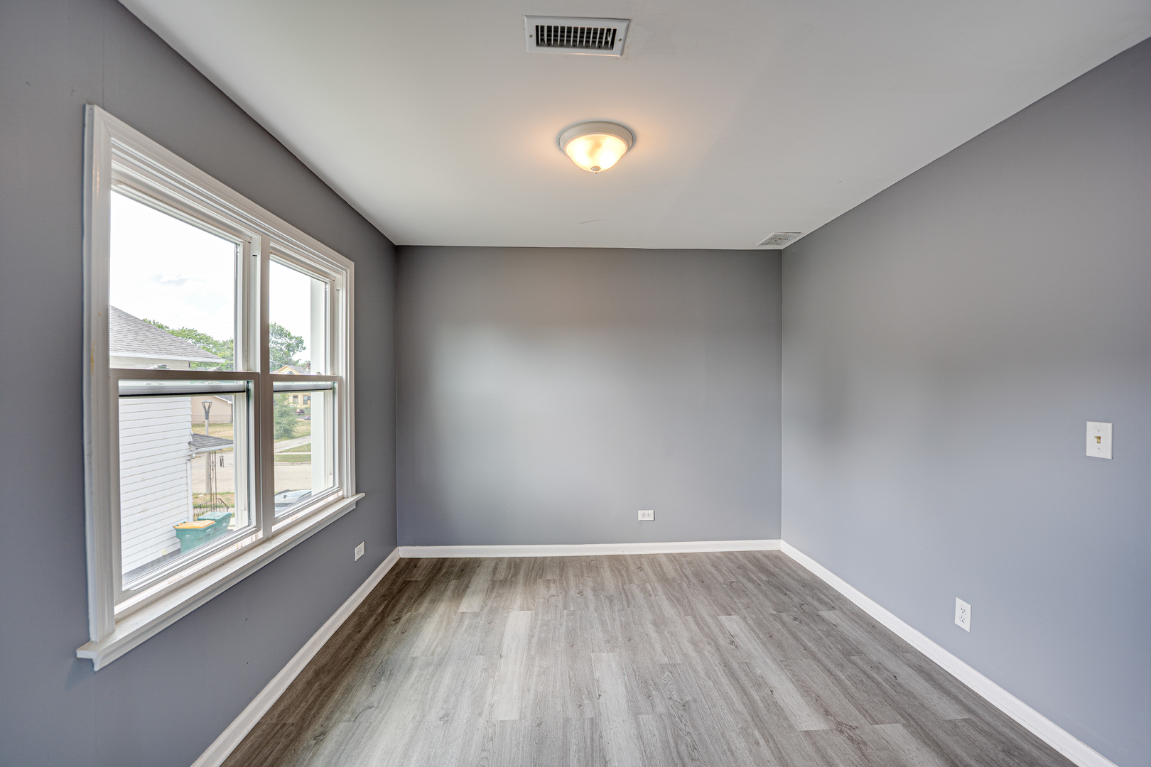 208 Mound Street, Unit 2 Joliet, IL 60433 - Photo 14 of 18 an empty room with wooden floor and windows