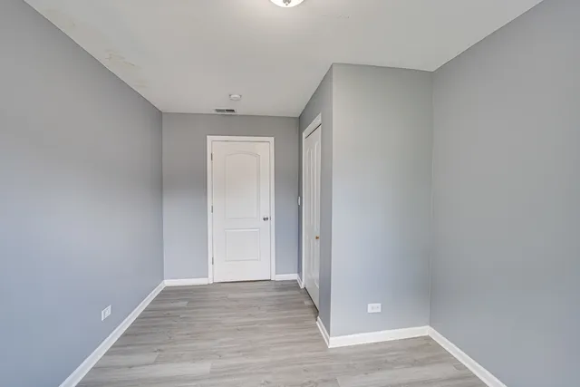 a view of an empty room with wooden floor