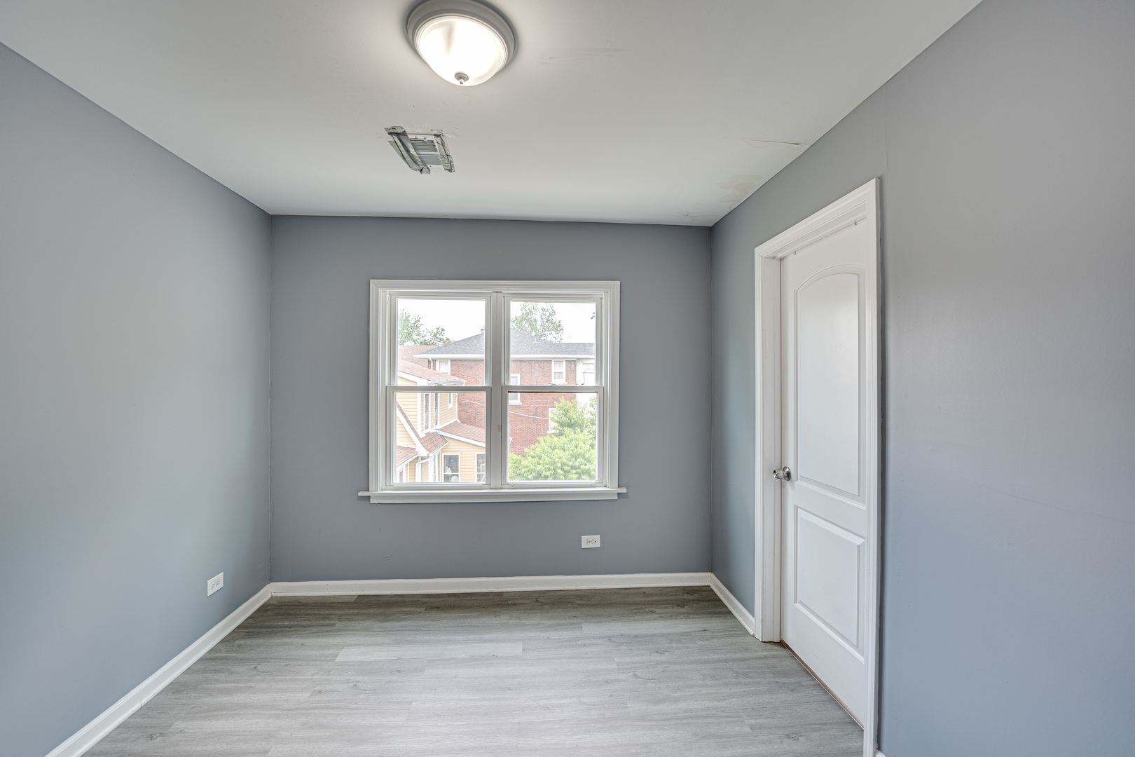 208 Mound Street, Unit 2 Joliet, IL 60433 - Photo 16 of 18 an empty room with wooden floor and windows