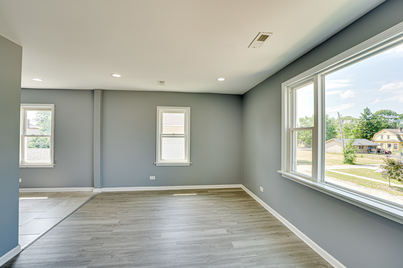 208 Mound Street, Unit 2 Joliet, IL 60433 - Photo 4 of 18 a view of an empty room with wooden floor and a window