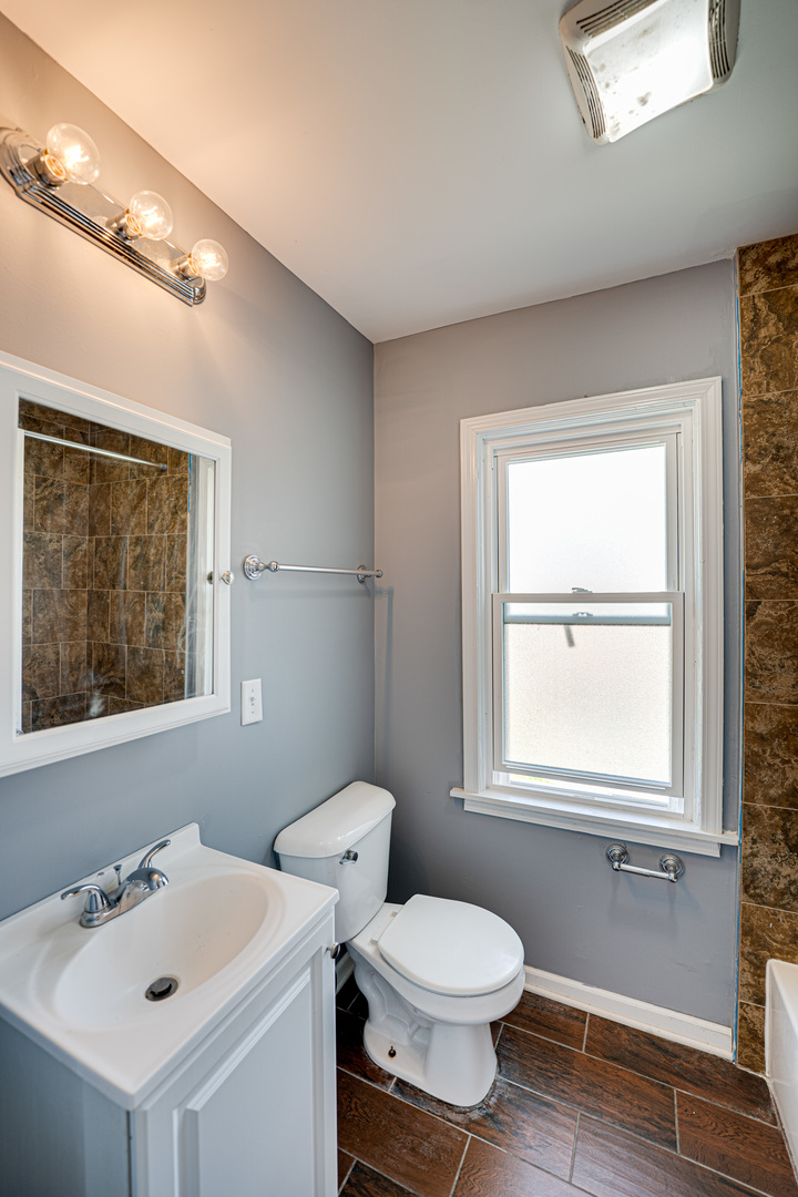 208 Mound Street, Unit 2 Joliet, IL 60433 - Photo 9 of 18 a bathroom with a toilet sink and mirror