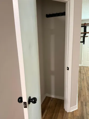 an empty room with wooden floor and entrance