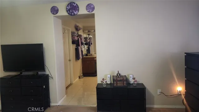 a view of a hallway with workspace and a flat screen tv