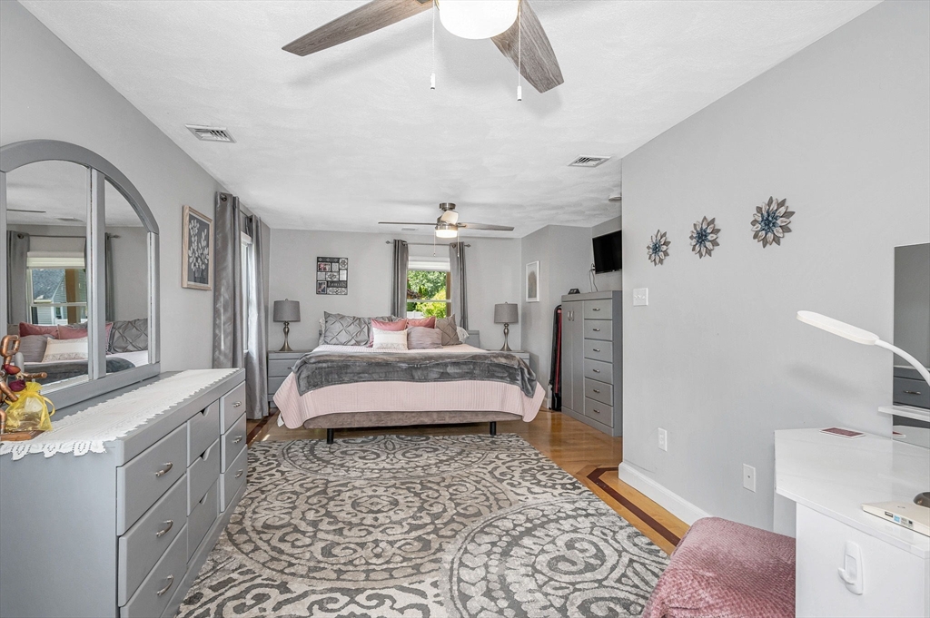 180 Foster Road Tewksbury, MA 01876 - Photo 14 of 38 a spacious bedroom with a bed a couch and a window