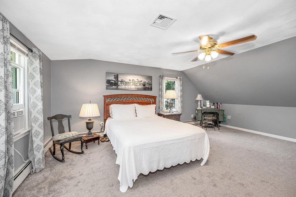 180 Foster Road Tewksbury, MA 01876 - Photo 17 of 38 a bedroom with a bed and a chandelier