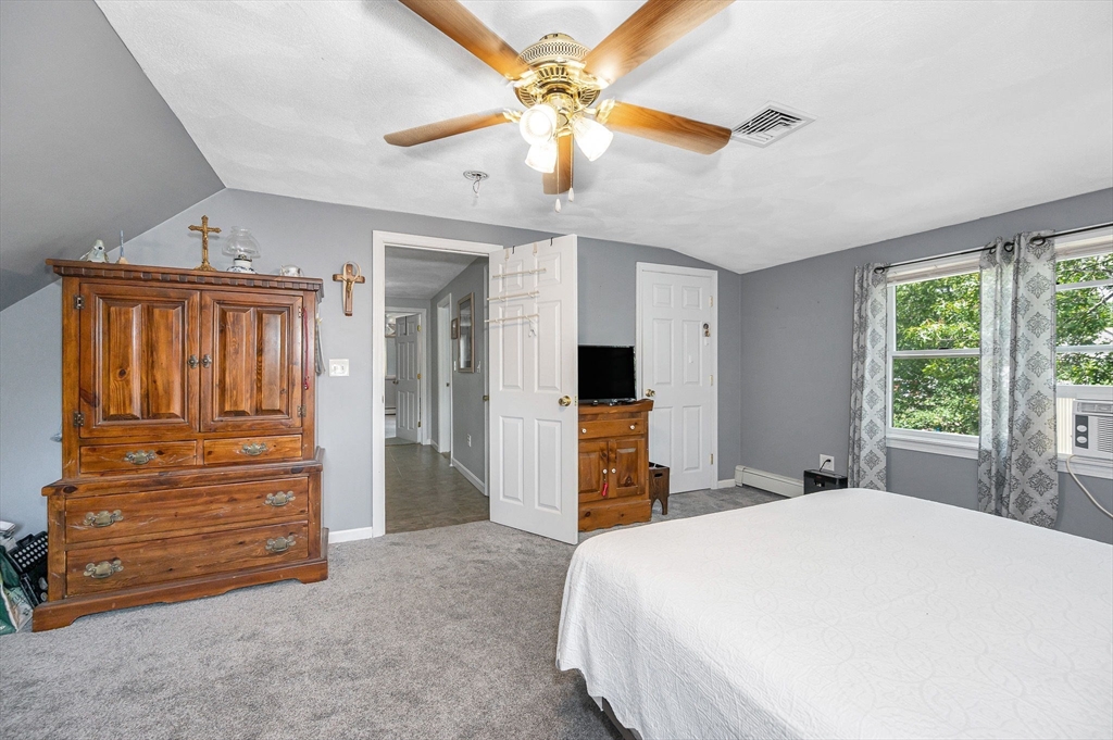 180 Foster Road Tewksbury, MA 01876 - Photo 18 of 38 a bedroom with a bed and a chandelier
