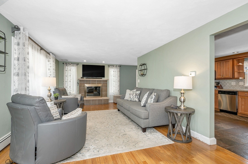 180 Foster Road Tewksbury, MA 01876 - Photo 3 of 38 a living room with furniture a fireplace and a flat screen tv